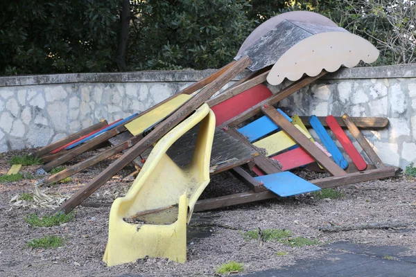 Slide broken and abandoned in a deserted playground after the di — Stock Photo, Image