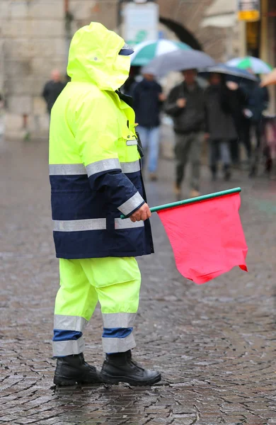 policeman with the red flag to signal the roadblock