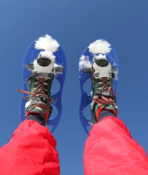 Snowshoes and Red Ski suit in the mountains — 图库照片