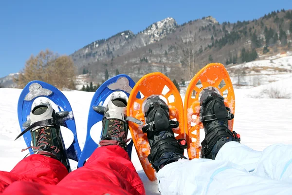 Marido e mulher com sapatos de neve nas montanhas — Fotografia de Stock