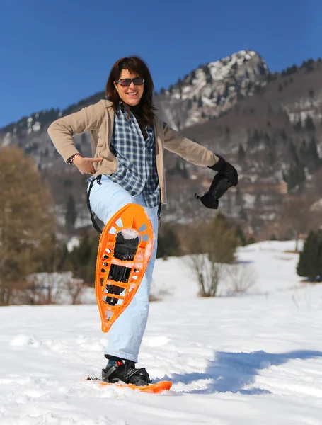 Beautiful smiling woman with snowshoes in winter — Stock Photo, Image