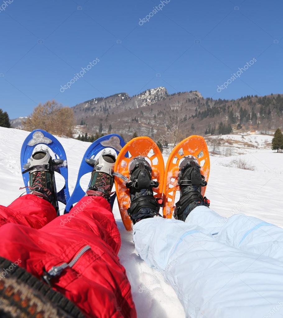 husband and wife with snowshoes in the mountains