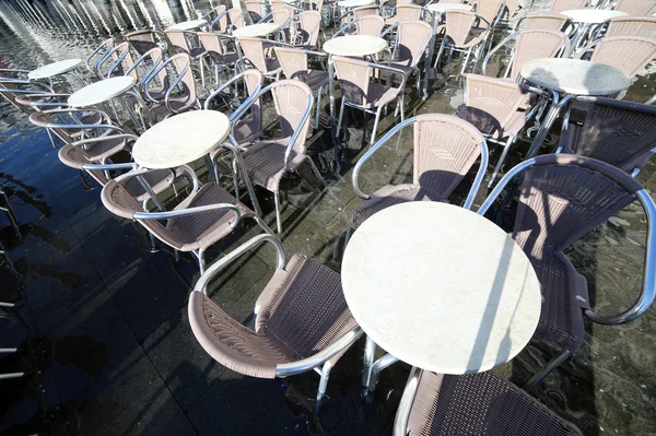Venice, chairs of the outdoor cafes with water at high tide — Stock Photo, Image