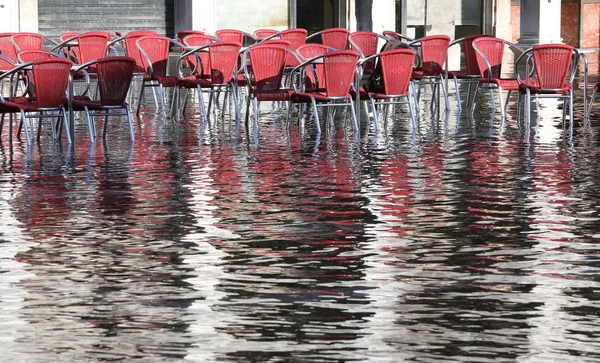 Stühle der Außencafés mit Wasser bei Flut — Stockfoto