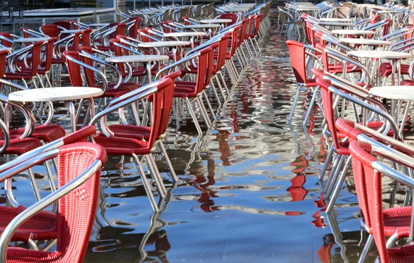 Veneza, cadeiras dos cafés com água na maré alta — Fotografia de Stock