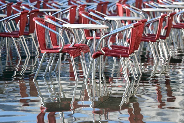 Venice, chairs of the outdoor cafes with water at high tide — Stock Photo, Image