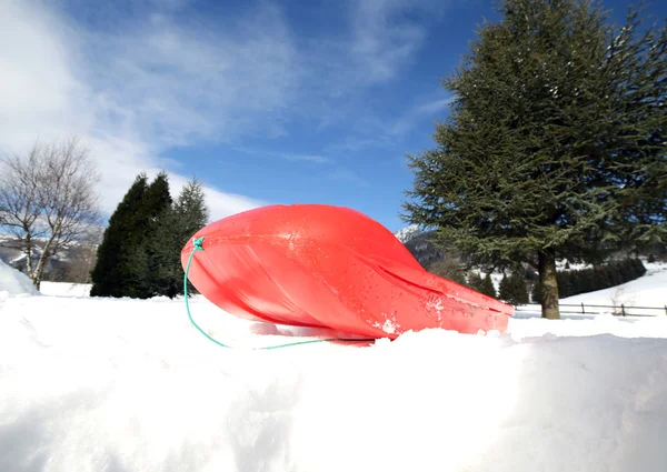 Bob rouge pour jouer dans la neige en montagne en hiver — Photo