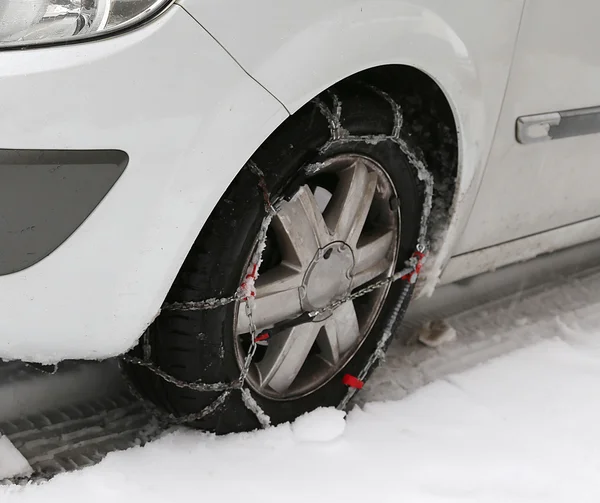 Pneu de carro com correntes de neve no inverno — Fotografia de Stock