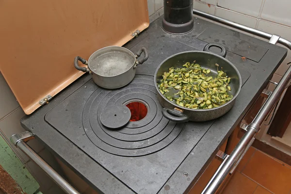 Cacerola con calabacín al horno en estufa de hierro fundido con fuego encendido — Foto de Stock