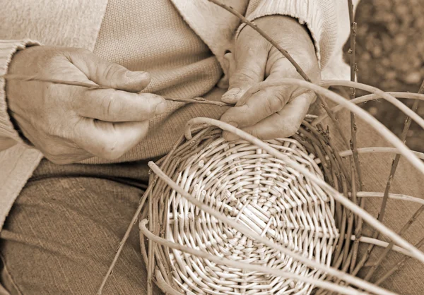 Експертні руки літнього майстра створюють плетену базу — стокове фото