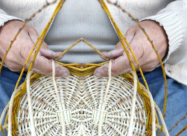 Vieil artisan crée un panier en osier tissé — Photo