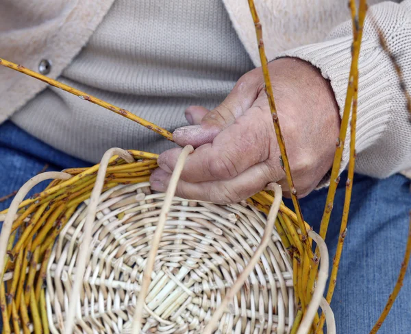 Senior craftsman creates a handmade wicker basket — Stock Photo, Image