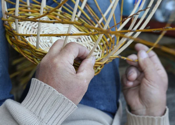 Fachkundige Hände eines Handwerkers schaffen einen geflochtenen Weidenkorb — Stockfoto