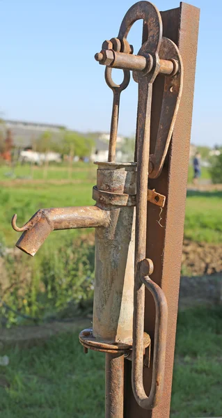 Rusted fountain with the lever to pump water — Stock Photo, Image