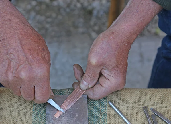 Manos de artesano durante el procesamiento de una herramienta de cobre — Foto de Stock