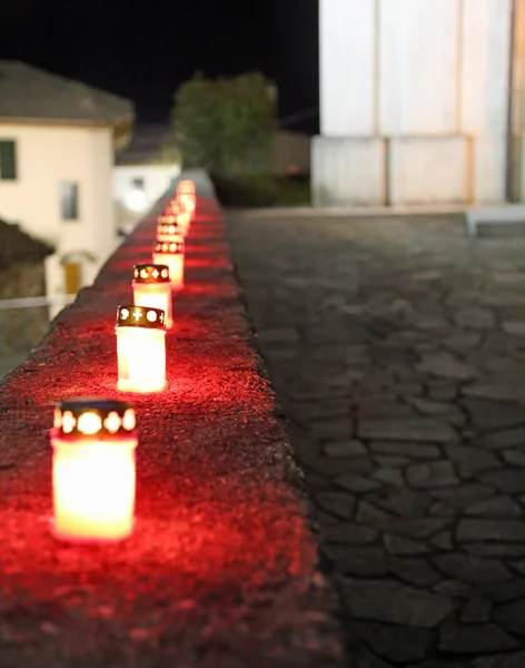 Červené svíčky na hřbitově během mše venku v noci — Stock fotografie