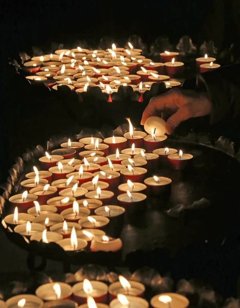 Mulher acende uma vela para rezar durante a missa na Igreja — Fotografia de Stock