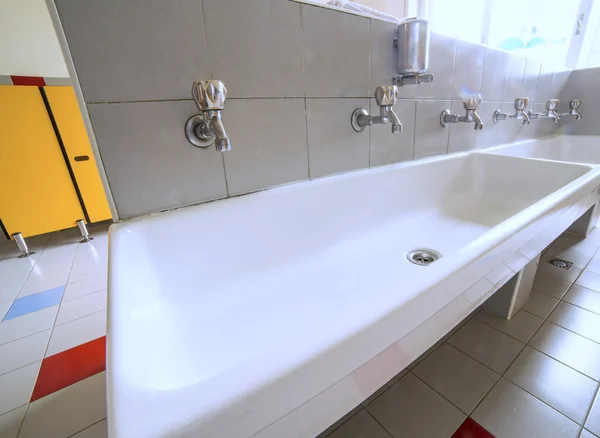 Ceramic sink with many taps in the school — Stock Photo, Image