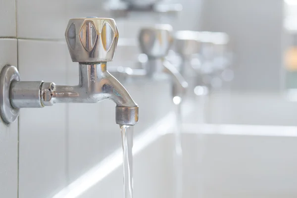 Grifos de acero inoxidable en el baño de la escuela — Foto de Stock