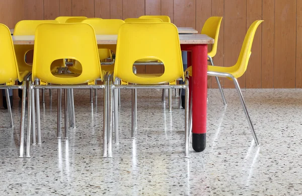 Gele stoelen en tafels in de kleuterschool — Stockfoto