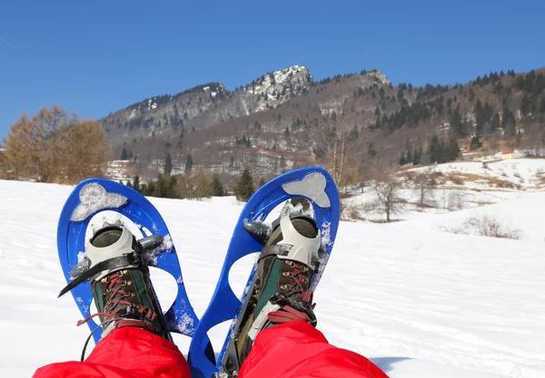 Pernas de alpinista com sapatos de neve para excursões na neve — Fotografia de Stock