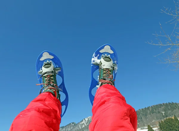 Mountaineer's legs with snowshoes for excursions in the mountain — Stock Photo, Image