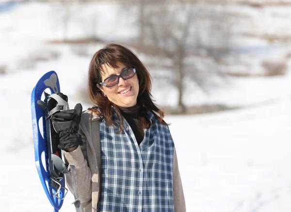 Pretty woman with snowshoes in the mountains in winter — Stock Photo, Image