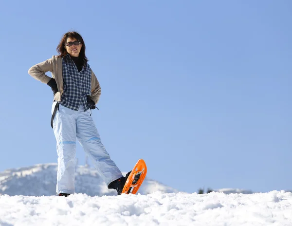 Vacker kvinna med snöskor i bergen på vintern — Stockfoto