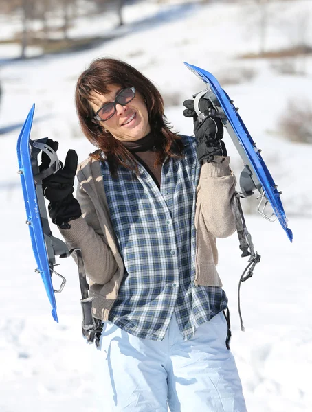 Mulher com sapatos de neve nas montanhas — Fotografia de Stock