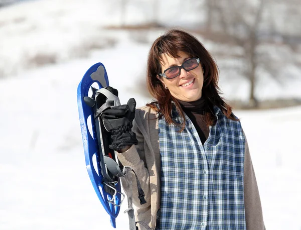 Vacker kvinna med snöskor i bergen på vintern — Stockfoto