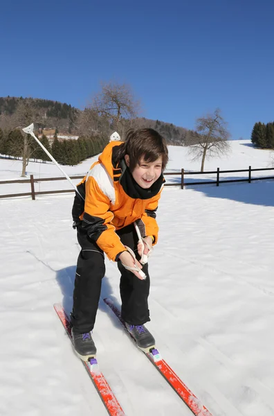 Jovem rapaz vai em esqui cross-country na neve branca no — Fotografia de Stock