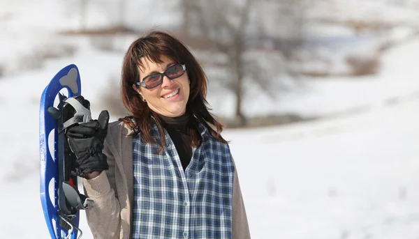 Pretty woman with snowshoes in the mountains in winter — Stock Photo, Image