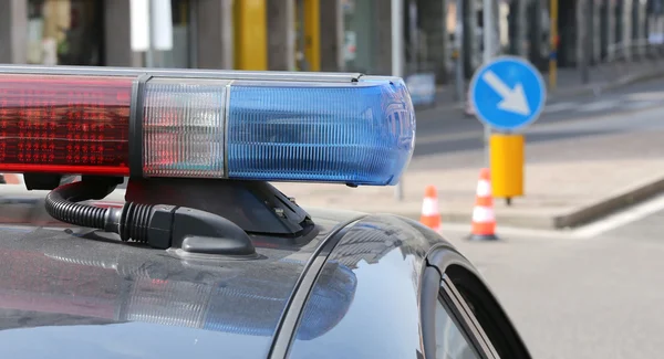 Azul e vermelho sirenes piscando de carro de polícia na cidade — Fotografia de Stock