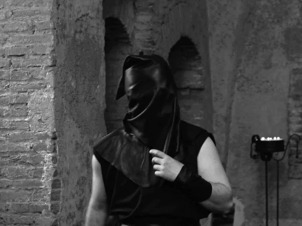 Bourreau avec capuche noire sur la tête dans le château — Photo