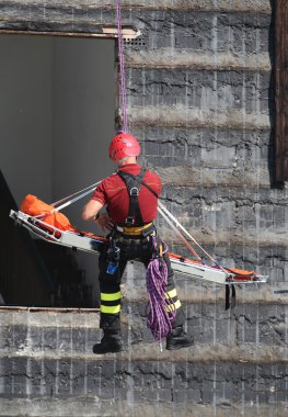 itfaiyeci bir egzersiz sırasında sedye climbi ile taşır