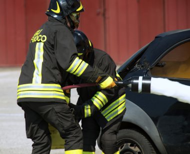 iki itfaiyeci Action köpüklü araba yangını söndürmek için