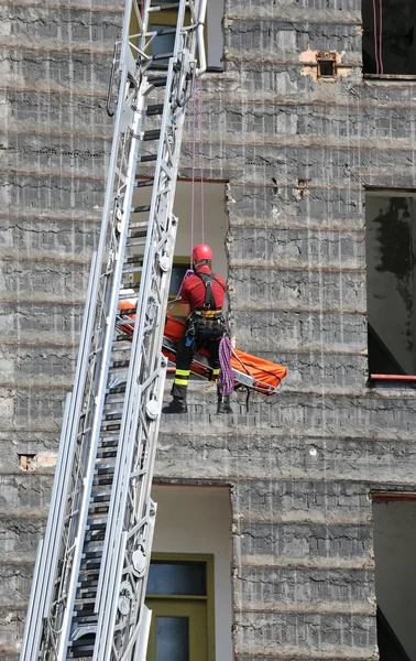 Coraggioso pompiere durante un esercizio porta la barella con la — Foto Stock