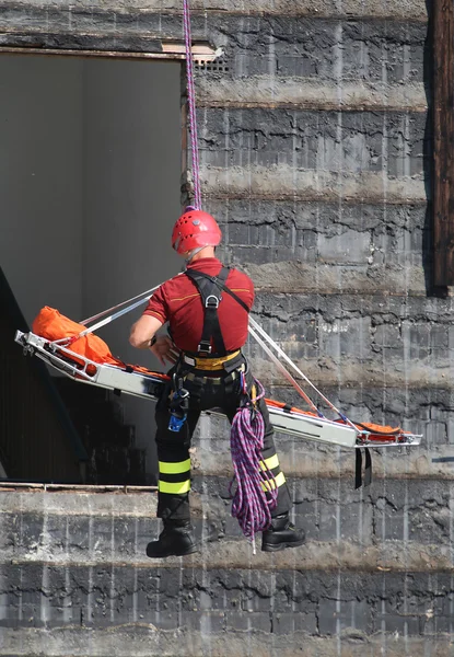 Bombero durante un ejercicio lleva la camilla con el climbi —  Fotos de Stock