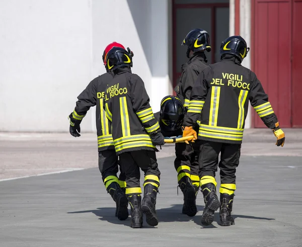 四个英勇的消防队员进行同伴的消防队员 — 图库照片