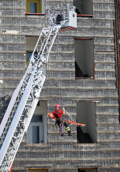Brandman under en övning bär båren med repet — Stockfoto