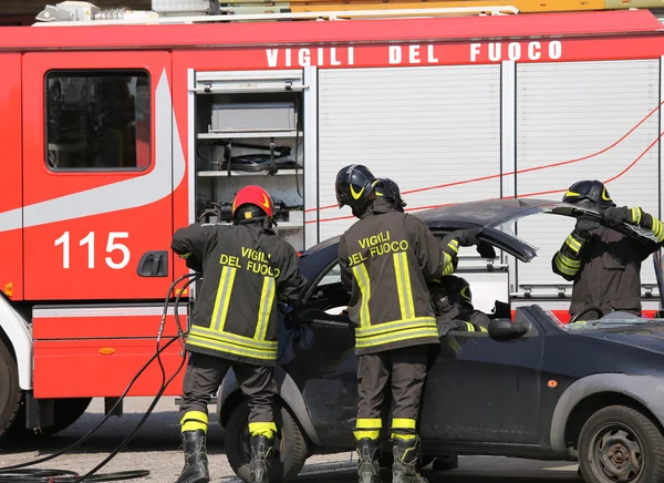 Brandweerlieden opstijgen de kap van de auto na een auto-ongeluk — Stockfoto