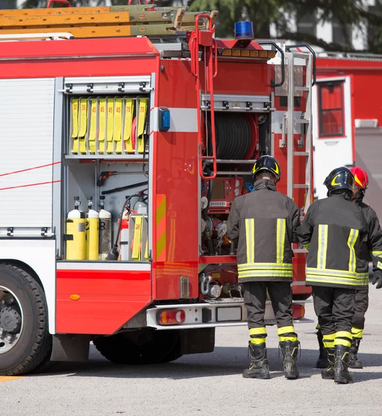 Firefighters and fire trucks during an emergency — Stock Photo, Image