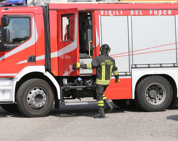 Vigili del fuoco italiani durante un'emergenza con tute protettive a — Foto Stock