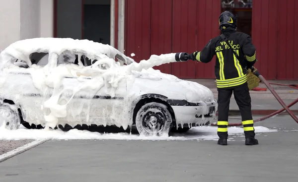 Firefighters during exercise to extinguish a fire in a car — Stock Photo, Image