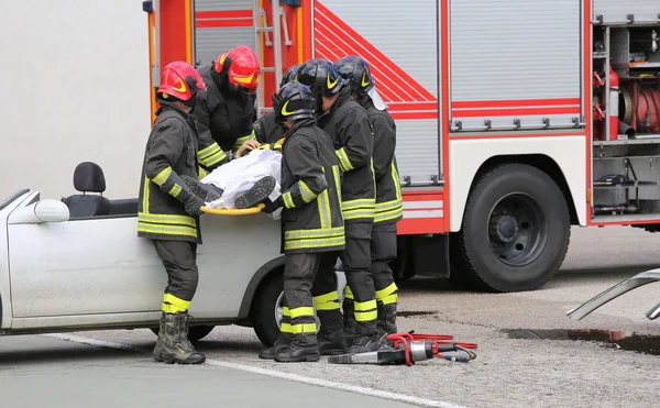 Pompiers soulager un blessé après un accident de voiture — Photo