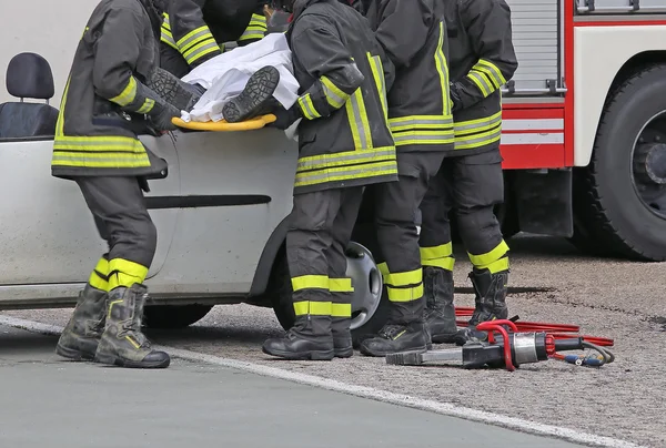 Pompiers soulager un blessé après un accident de voiture — Photo