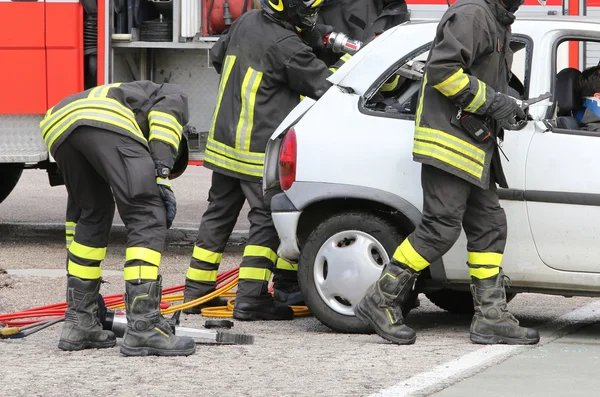 Pompiers courageux soulager un blessé après un accident de la route — Photo
