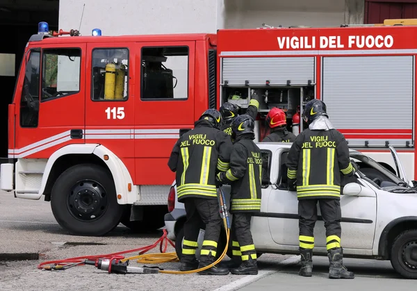 Moedige brandweerlieden verlichten een gewonde na een auto-ongeluk — Stockfoto