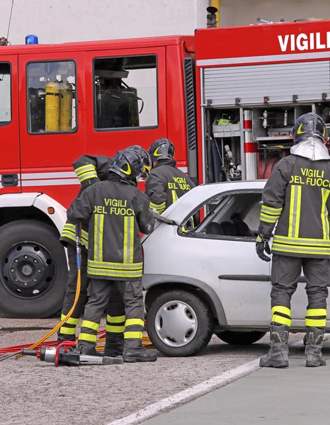 Coraggiosi vigili del fuoco alleviare un ferito dopo un incidente stradale — Foto Stock