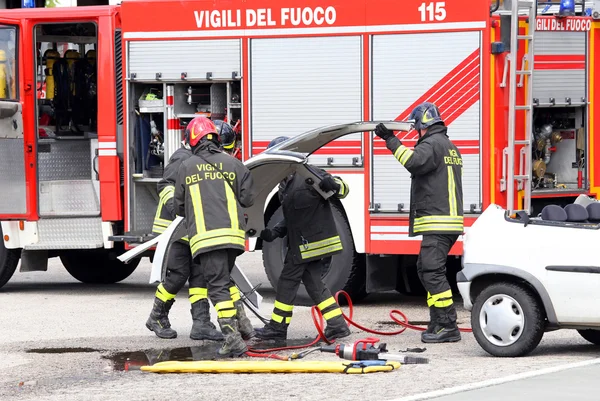 Bombero y accidente de tráfico con piezas de automóviles y el camión de bomberos — Foto de Stock